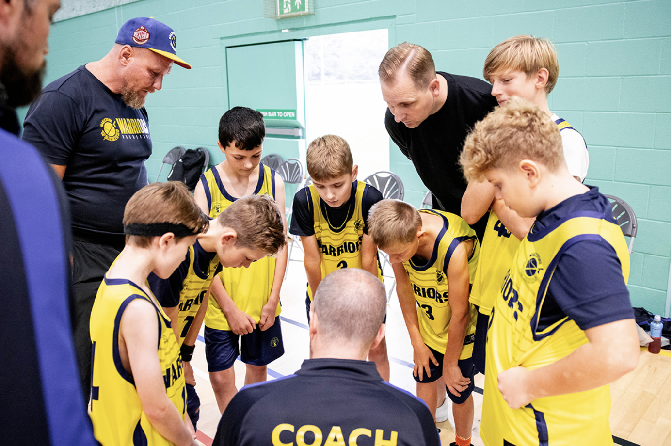 Medway youth team in a huddle with their coach.